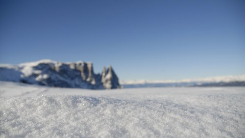 Presulis: Ihre Luxus-Ferienwohnung in Völs am Schlern Nahaufnahme von glitzerndem Schnee im Vordergrund mit Berglandschaft im Hintergrund