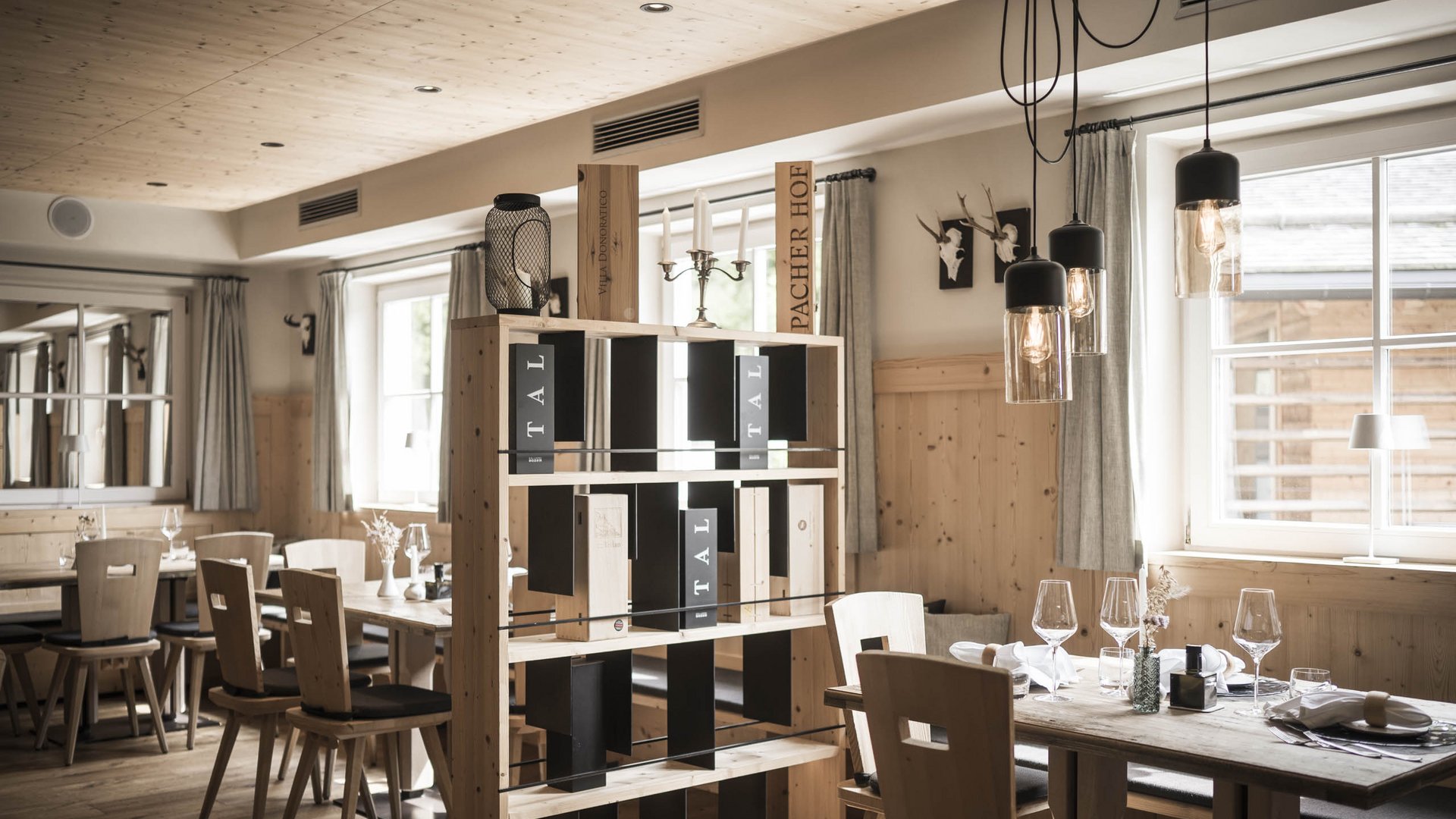 Pure indulgence in our restaurant in Völs am Schlern Cozy restaurant with wooden furniture and wine rack in natural light