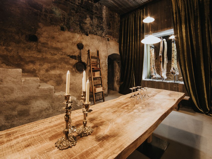 Pure indulgence in our restaurant in Völs am Schlern Rustic room with wooden table, candlesticks, and antique bones by the window