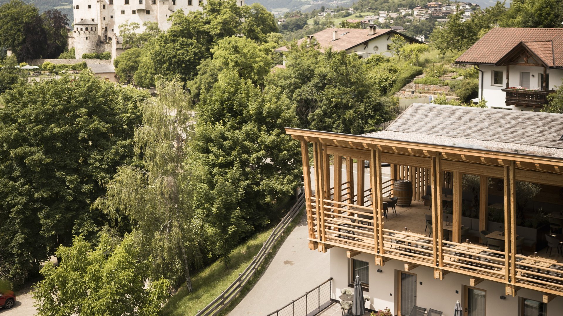 Presulis: Ihre Luxus-Ferienwohnung in Völs am Schlern Blick auf Schloss, Bäume, moderne Terrasse und Pool im Bergdorf
