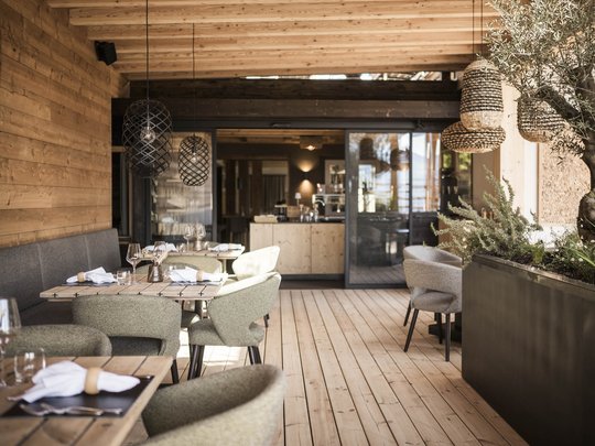 Presulis: Ihre Luxus-Ferienwohnung in Völs am Schlern Gemütliches Holzrestaurant mit Tischdekoration und modernen Stühlen