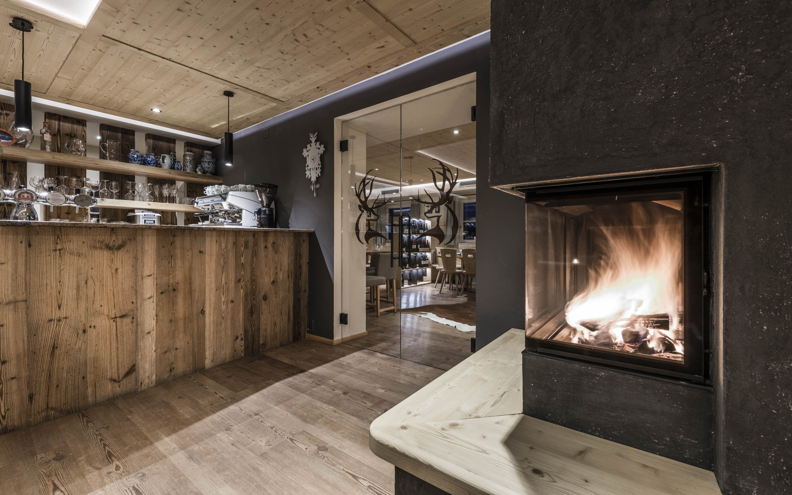 Presulis: Ihre Luxus-Ferienwohnung in Völs am Schlern Gemütliche Bar mit Holztheke und Kaminfeuer in modernem Restaurant
