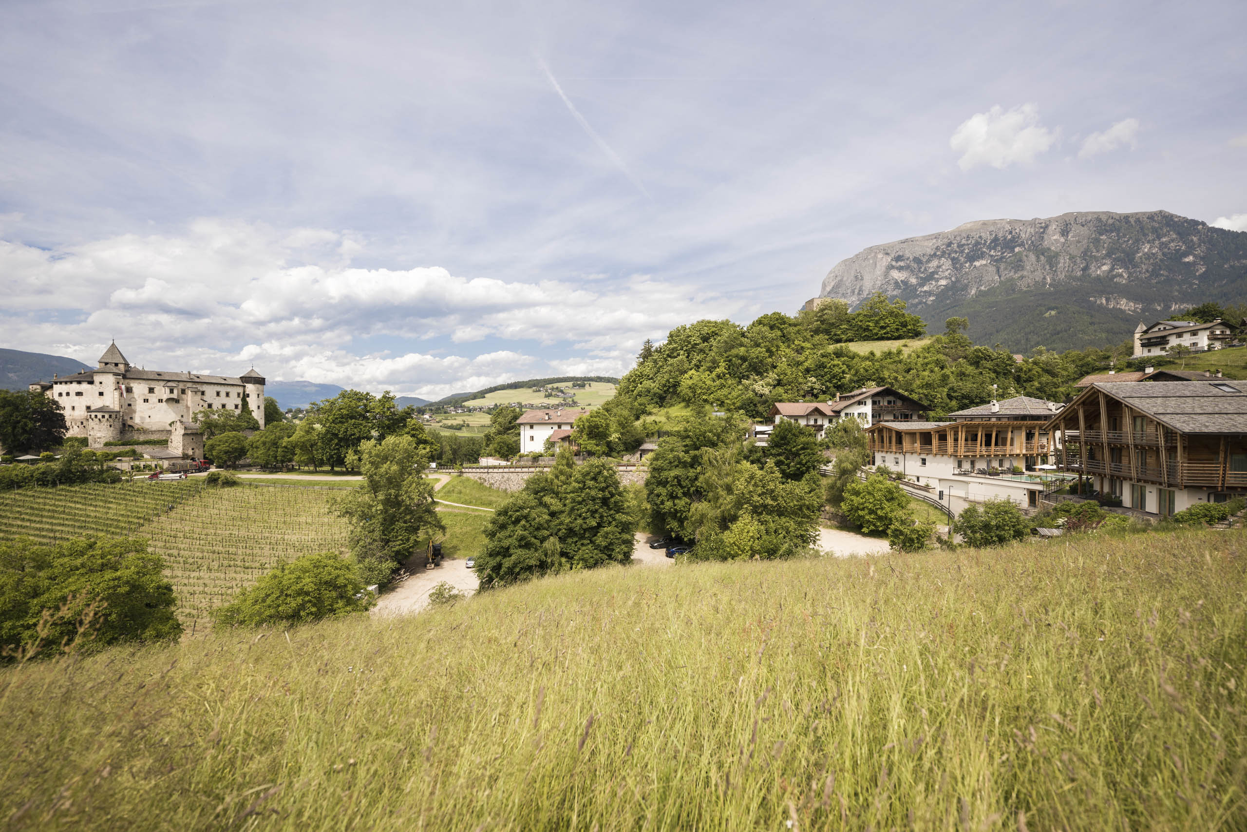 Presulis: Ihre Luxus-Ferienwohnung in Völs am Schlern Landschaft mit Schloss, grünen Wiesen und Bergen bei klarem Himmel